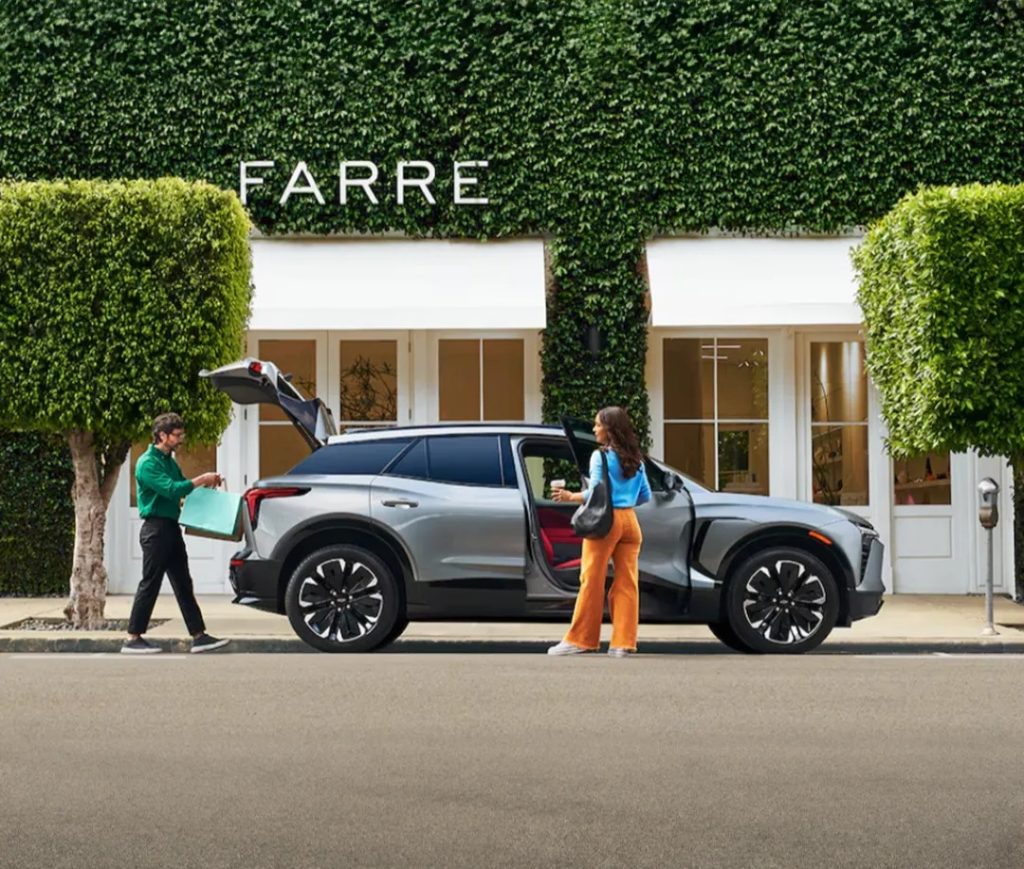 Chevy SUV with trunk open and woman getting out of passenger side