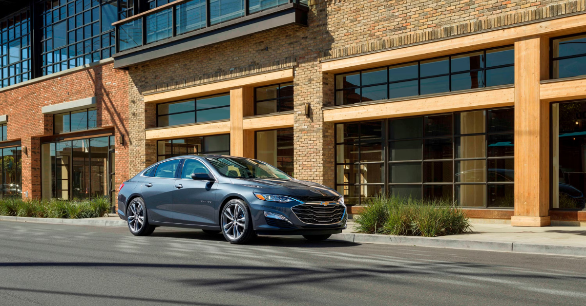 2025 Chevrolet Malibu sedan exterior in grey parked in front of a building
