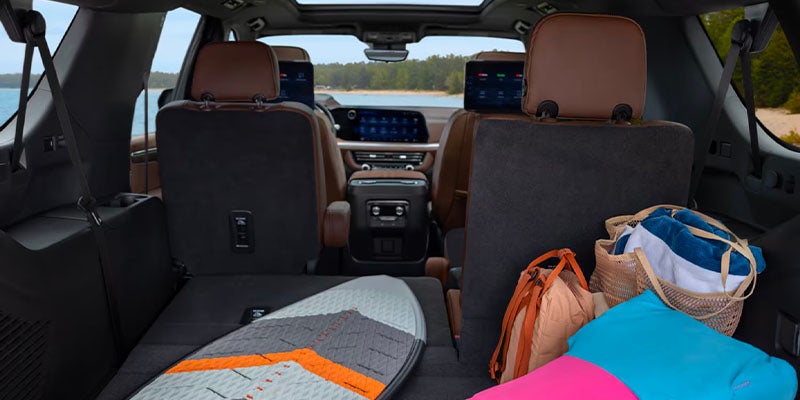 Interior view of a 2025 Chevrolet Suburban with backseats down and beach gear in trunk